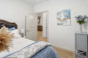 Bedroom featuring baseboards and light carpet