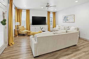 Living area with light wood-style flooring, a ceiling fan, recessed lighting, and wallpapered walls
