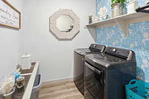 Laundry area featuring light wood-style flooring and washing machine and clothes dryer