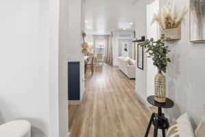 Hallway with light wood-style flooring and recessed lighting