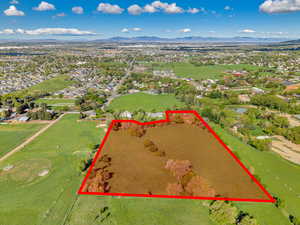 Aerial view of property and surrounding area featuring property parcel outlined and a mountain backdrop