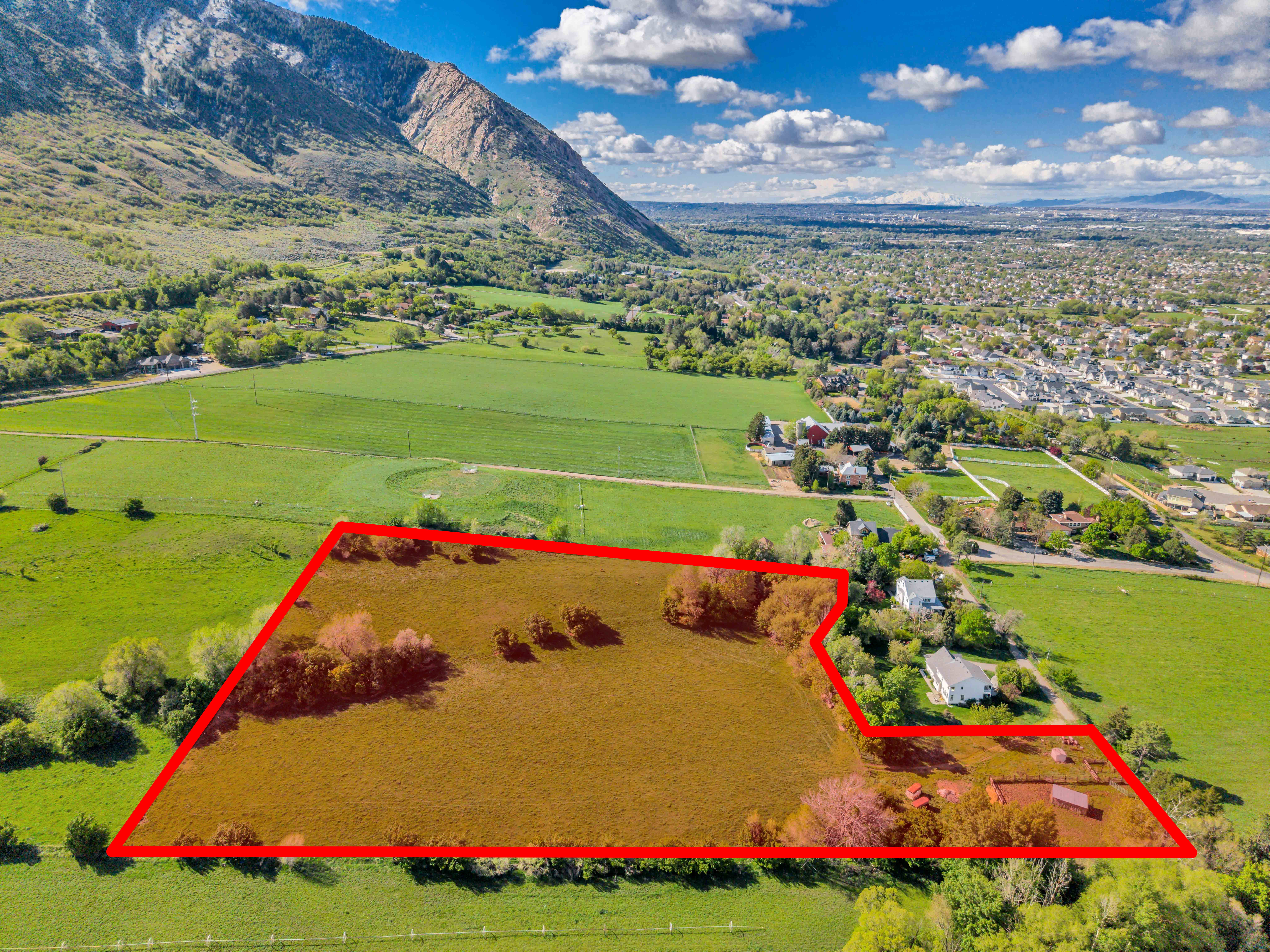 Aerial view of property's location with property parcel outlined and a mountain backdrop