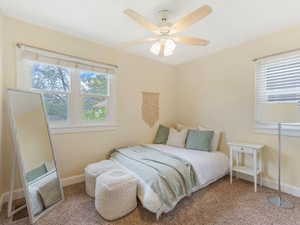 Carpeted bedroom with baseboards and a ceiling fan