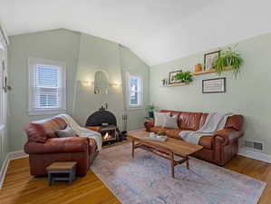 Living area with wood finished floors and vaulted ceiling