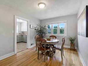 Dining space with light wood-type flooring and a textured ceiling