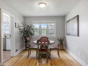 Dining area with light wood finished floors and a textured ceiling