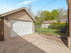 Detached garage featuring a gate and concrete driveway
