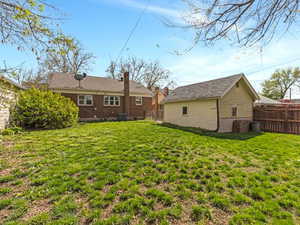 Rear view of house featuring a fenced backyard and a chimney