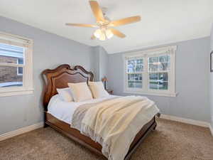Bedroom featuring a ceiling fan, carpet, and lofted ceiling