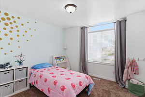 Bedroom featuring dark colored carpet and baseboards