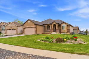 View of front facade with an attached garage, a porch, driveway, a front yard, and stucco siding