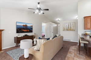 Living room featuring light carpet, lofted ceiling, and a ceiling fan