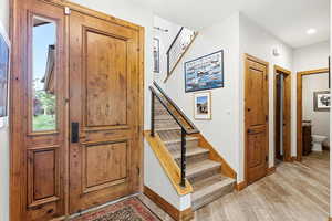 Staircase with wood finished floors and baseboards
