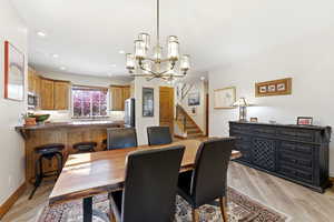 Dining space with hanging lights and light wood finished floors