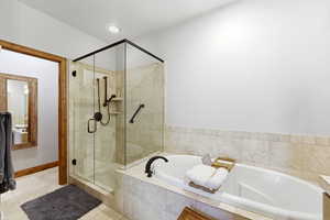 Bathroom featuring a shower stall, a bath, and light tile patterned flooring