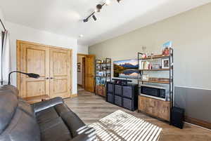 Living area with light wood-type flooring and rail lighting