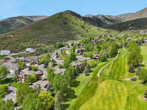 Aerial perspective of suburban area featuring mountains and a golf course