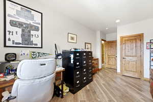 Office space with light wood-style flooring and recessed lighting