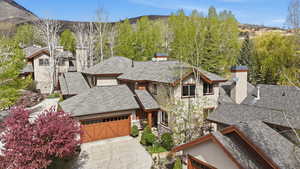 View of front facade with a chimney, a mountain view, driveway, and an attached garage