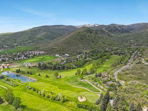 View of mountain backdrop featuring a local golf course and a nearby body of water