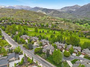 Aerial perspective of suburban area with mountains and a golf course