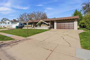 View of front of home with brick siding, concrete driveway, a garage, and a front yard