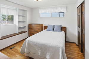 Bedroom featuring a textured ceiling, a closet, and light wood-type flooring