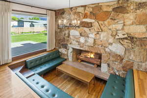 Living area featuring a fireplace, a chandelier, and wood finished floors