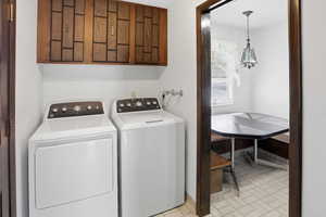 Laundry room with washer and clothes dryer and cabinet space