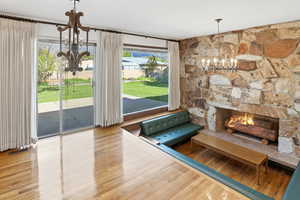 Living room with a chandelier, a fireplace, light wood finished floors