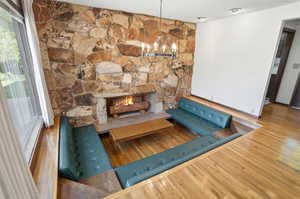 Detailed view of wood finished floors, a fireplace, a chandelier