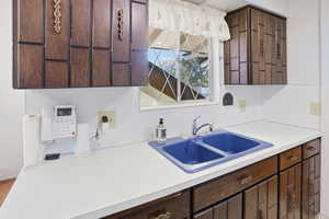 Kitchen featuring dark wood finish cabinetry and light countertops