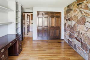 Bedroom or Office with light wood finished floors, a textured ceiling