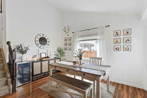 Dining room featuring vaulted ceiling, wood finished floors, and beverage cooler