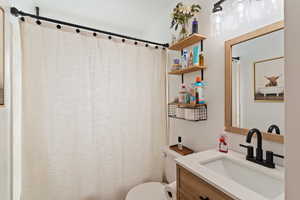 Full bath featuring vanity and curtained shower