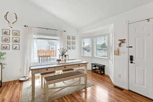 Dining room featuring light wood finished floors and vaulted ceiling
