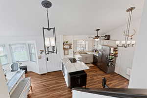 Kitchen featuring a chandelier, dark wood finished floors, a ceiling fan, vaulted ceiling, and stainless steel appliances