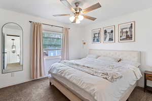 Bedroom featuring dark colored carpet and a ceiling fan