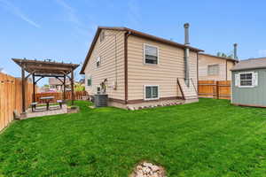 Rear view of property featuring a fenced backyard, a pergola, a patio, and an outdoor structure