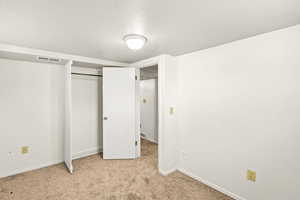 Unfurnished bedroom featuring light colored carpet and a closet