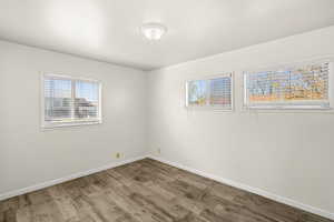 Unfurnished room featuring wood finished floors and baseboards