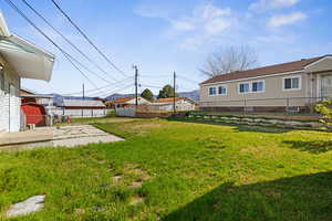 Fenced backyard featuring a residential view and a patio area