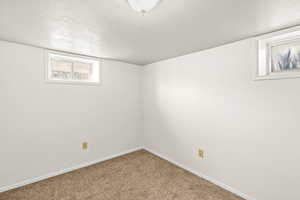 Below grade area with a textured ceiling and carpet