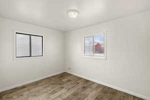 Unfurnished room featuring wood finished floors and baseboards