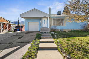 View of front of house with an attached garage, driveway, and a mountain view