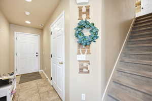 Doorway to outside with tile patterned flooring and recessed lighting
