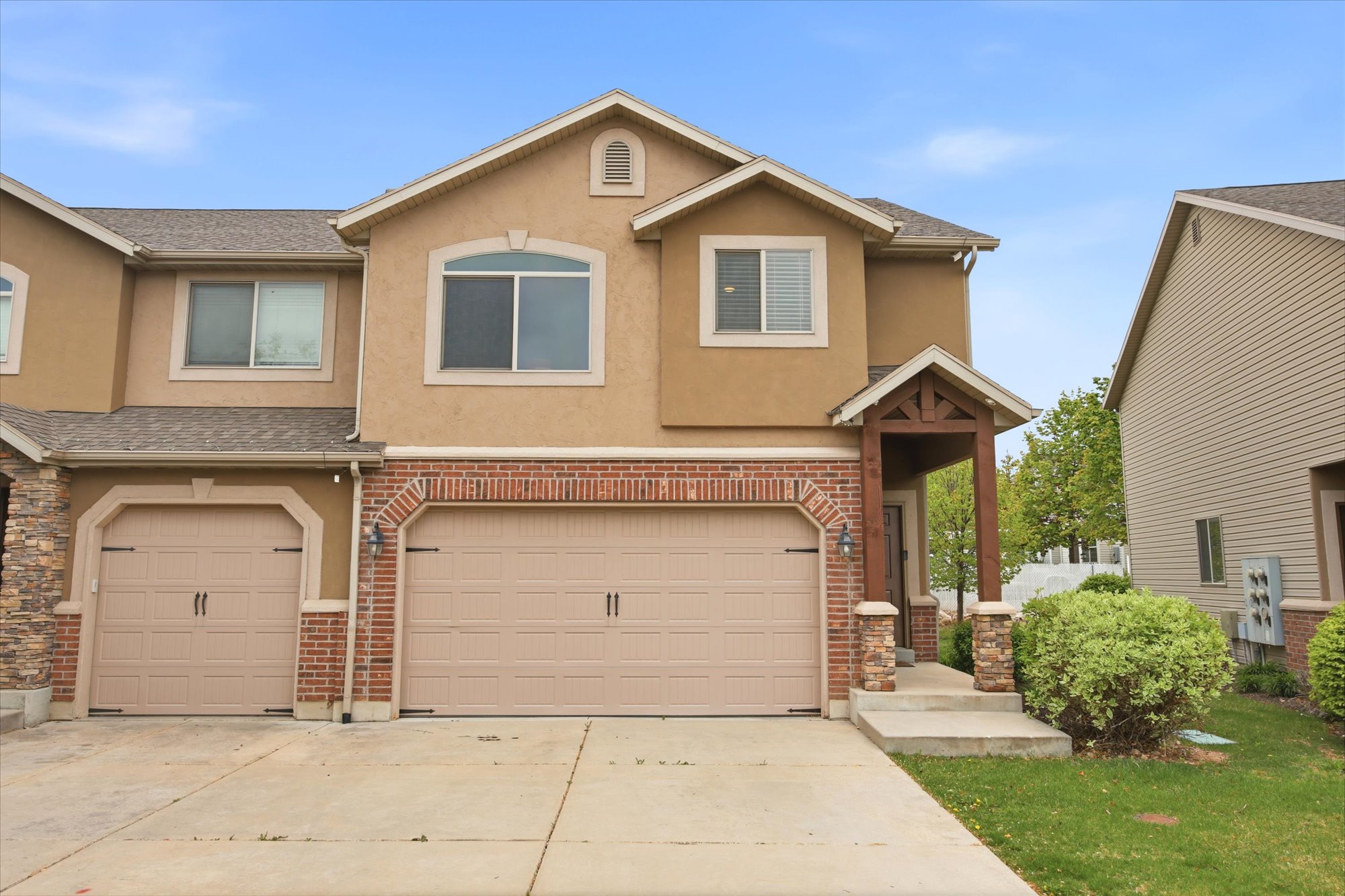 Traditional-style home featuring a garage, stucco siding, concrete driveway, and roof with shingles