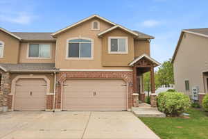 Traditional-style home featuring a garage, stucco siding, concrete driveway, and roof with shingles