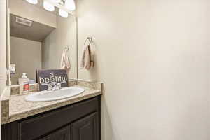 Bathroom with vanity and a textured wall
