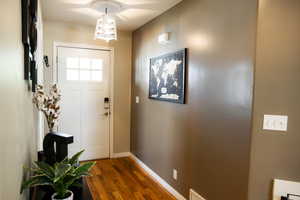 Doorway featuring wood finished floors and baseboards